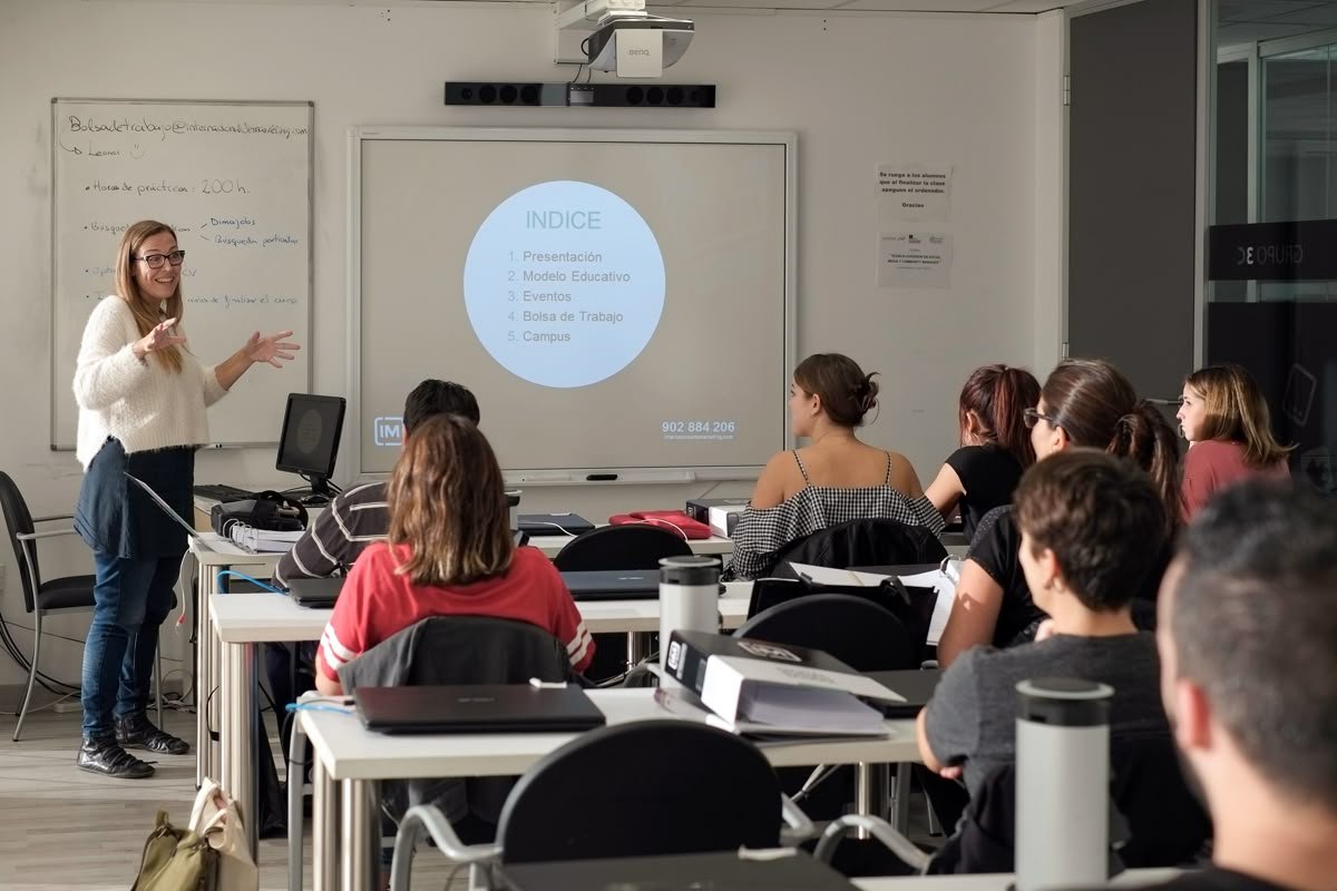 Formadora a dinamizar uma sessão presencial em sala, com participantes sentados em grupo